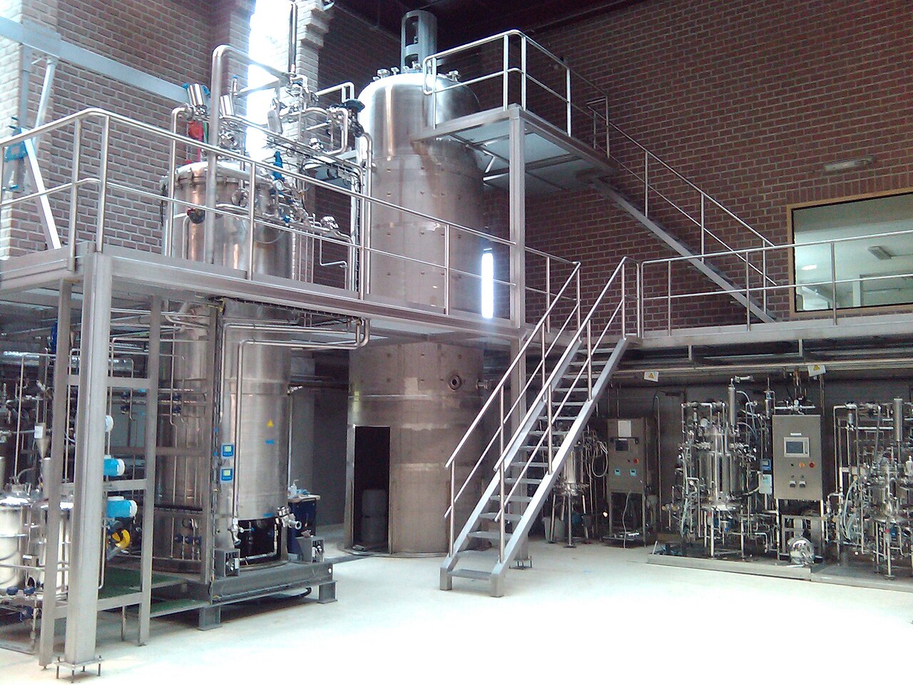 Industrial 15,000-litre stainless-steel fermenters with platforms, separation equipment and plant controls